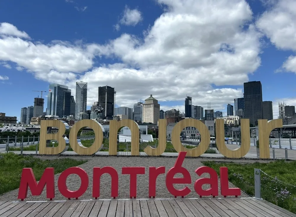 Bonjour Montréal sign with the downtown Montreal skyline behind it